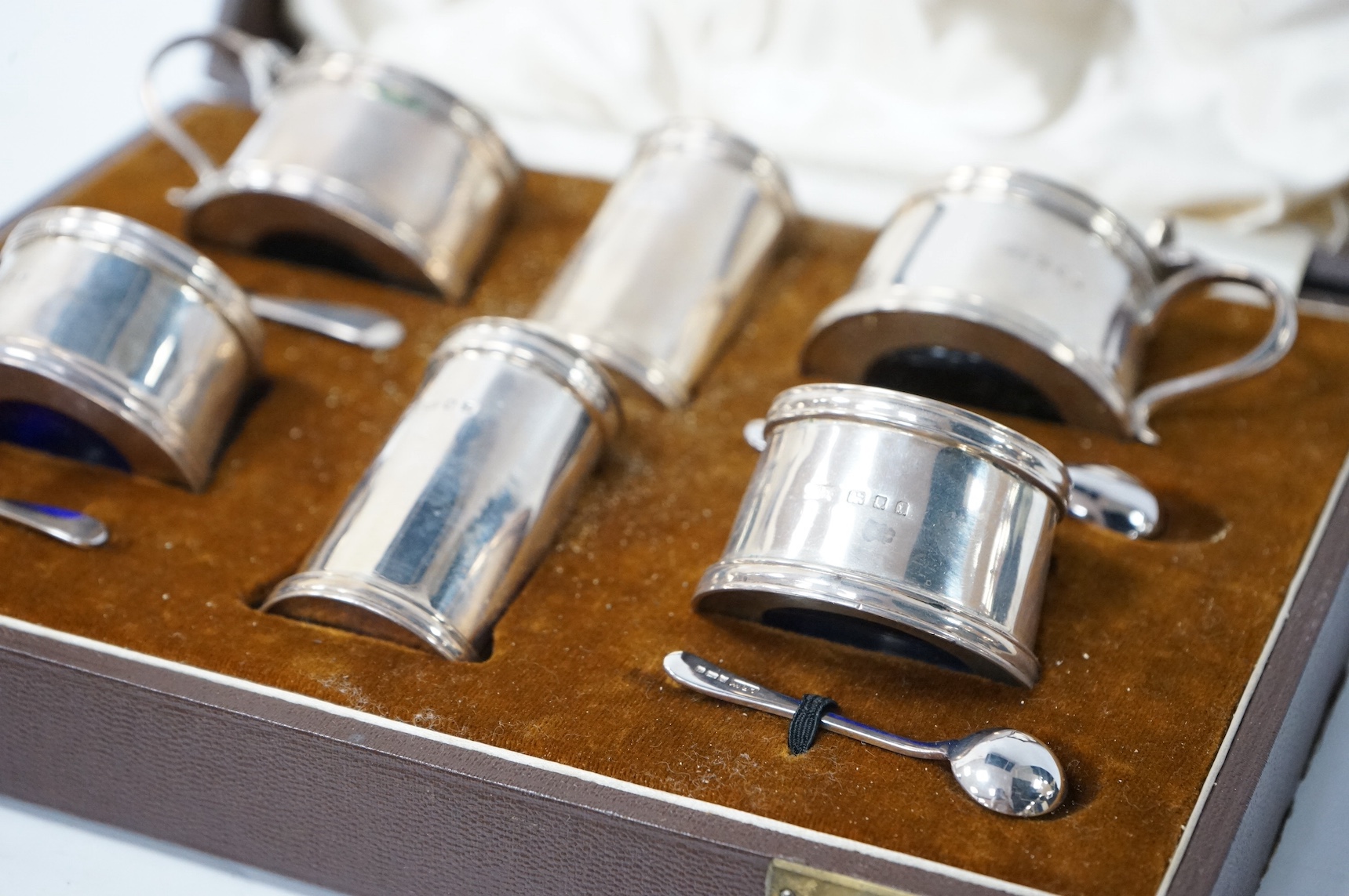 A cased George V silver six piece condiment set, by Josiah Williams & Co, with four later associated silver condiment spoons. Condition - fair